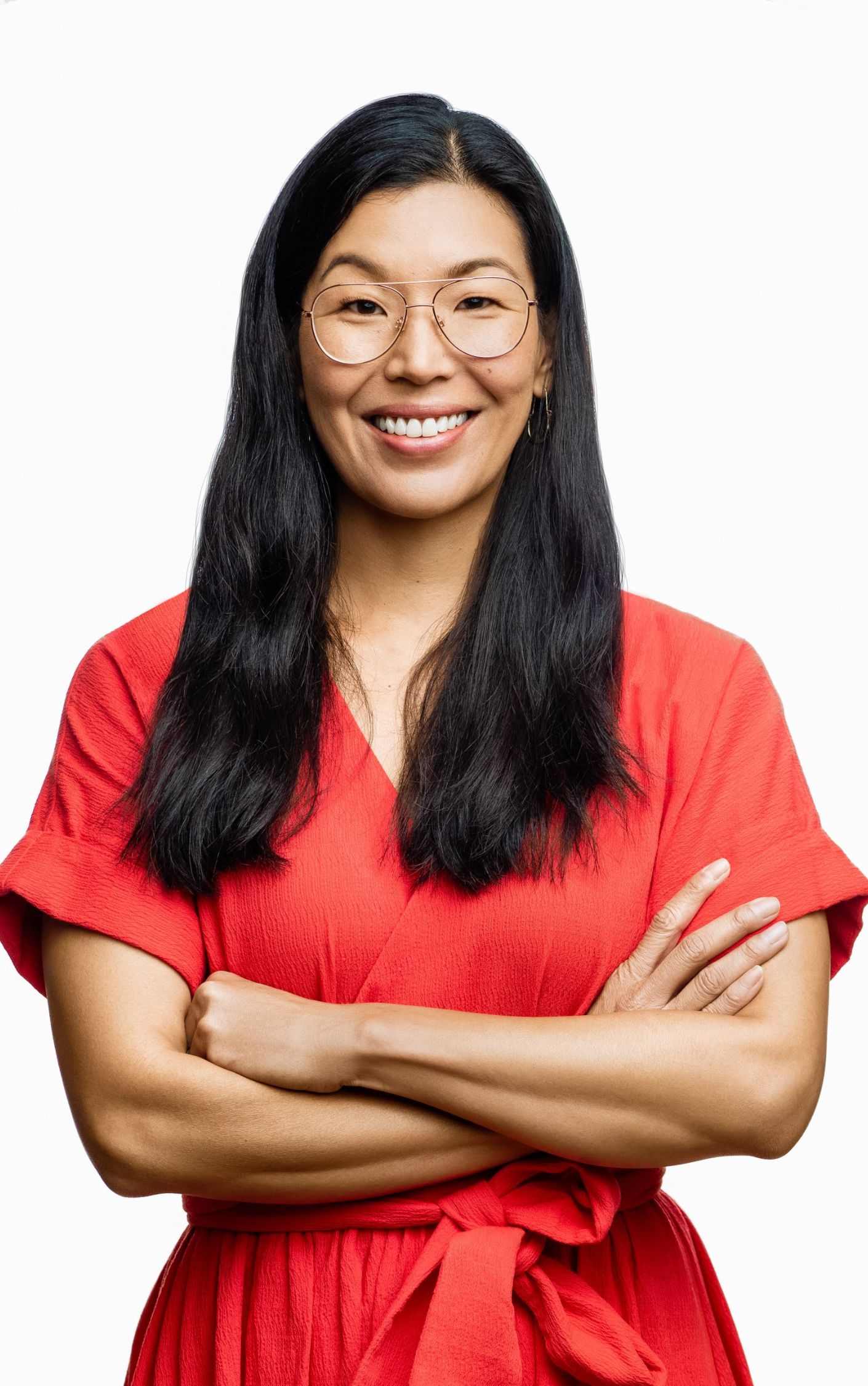 Portrait of Ai-jen Poo, Chinese American labor organizer and founder of the National Domestic Workers Alliance, smiling confidently in a red dress. A leading advocate for immigrant women in the care economy, Poo has championed dignity and labor rights for nannies, housekeepers, and caregivers across the U.S.